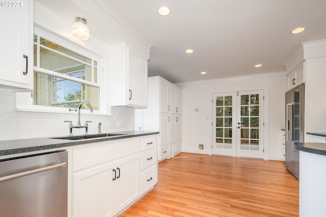 kitchen with appliances with stainless steel finishes, white cabinetry, and sink