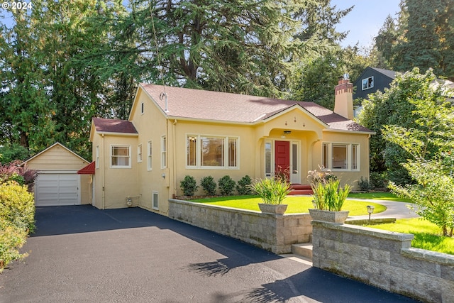 view of front of property with a front yard, an outbuilding, and a garage