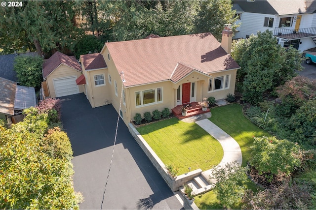 view of front of property with a garage, an outdoor structure, and a front yard