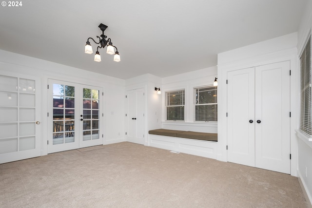 interior space with french doors and a chandelier