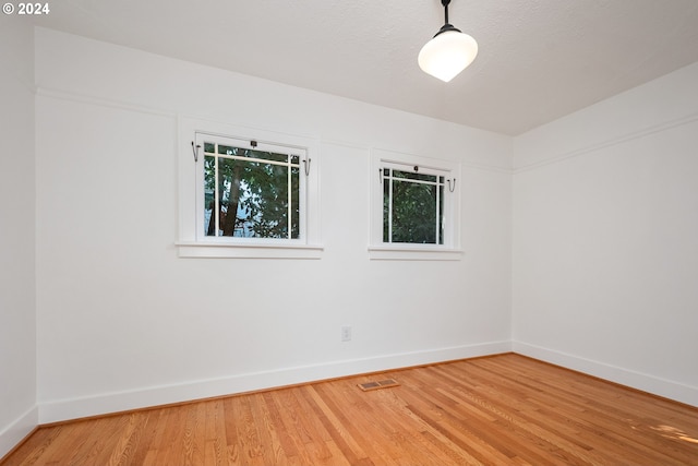 empty room featuring a textured ceiling and hardwood / wood-style floors