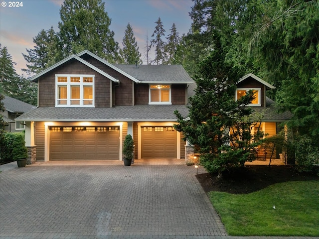 craftsman inspired home with decorative driveway and a garage