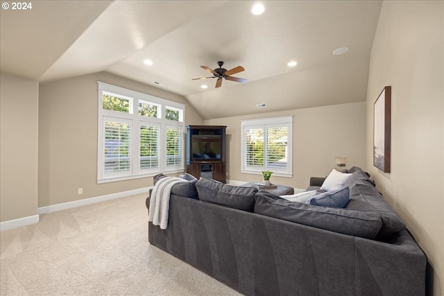 living room featuring vaulted ceiling, baseboards, a wealth of natural light, and light colored carpet