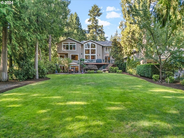 back of house featuring a lawn and stairway