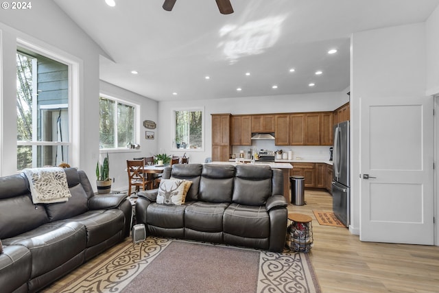 living room featuring ceiling fan and light hardwood / wood-style flooring