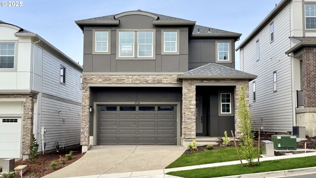 view of front of home featuring concrete driveway, stone siding, a shingled roof, and a garage
