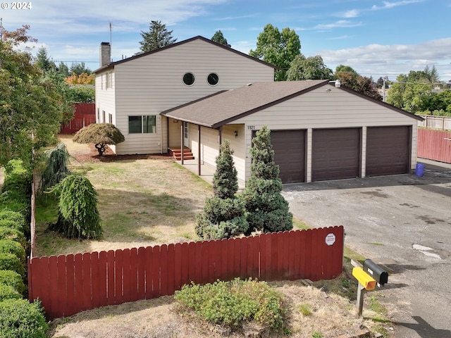 view of front of house featuring fence, a garage, driveway, and a chimney