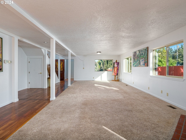 empty room featuring a textured ceiling and dark wood-type flooring