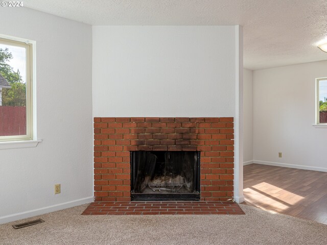 interior details with a textured ceiling, a fireplace, and hardwood / wood-style flooring