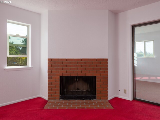 room details featuring a textured ceiling, carpet flooring, and a brick fireplace