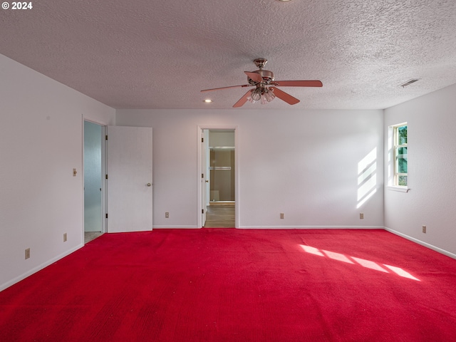 empty room with carpet, ceiling fan, and a textured ceiling