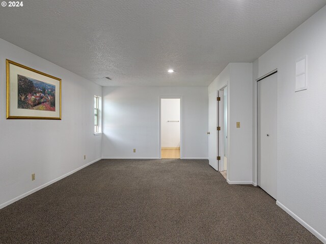 empty room featuring a textured ceiling and carpet flooring