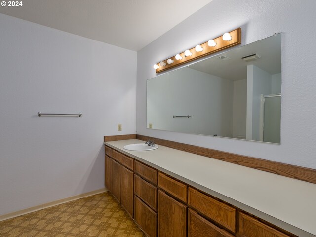 bathroom with walk in shower and vanity