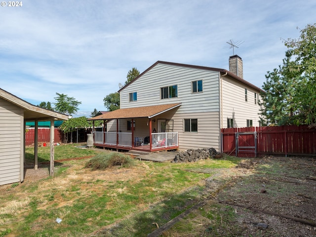 back of house with a deck