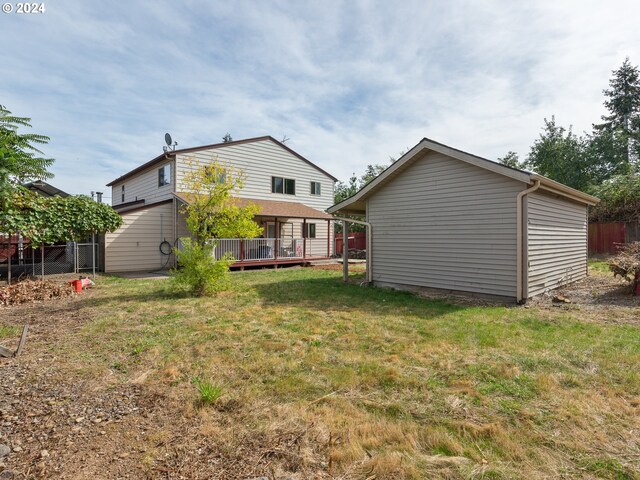 back of property featuring a lawn and a wooden deck