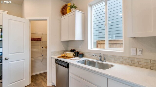 kitchen with dishwasher, sink, white cabinetry, and light hardwood / wood-style floors