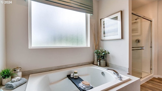 bathroom featuring separate shower and tub, plenty of natural light, and hardwood / wood-style floors