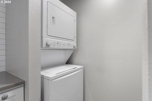 washroom featuring stacked washing maching and dryer