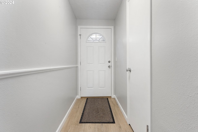 entryway with a textured ceiling and light hardwood / wood-style flooring