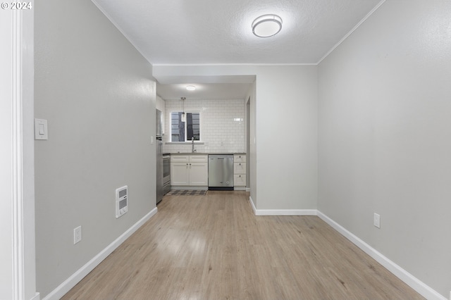 interior space featuring tasteful backsplash, heating unit, crown molding, sink, and hardwood / wood-style floors