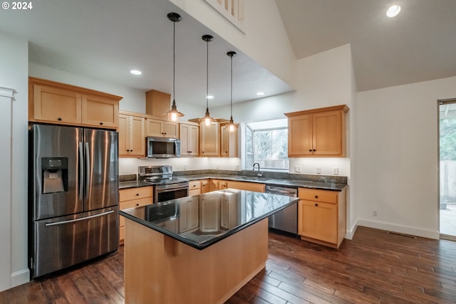 kitchen featuring appliances with stainless steel finishes, dark hardwood / wood-style flooring, a kitchen island, hanging light fixtures, and a breakfast bar area