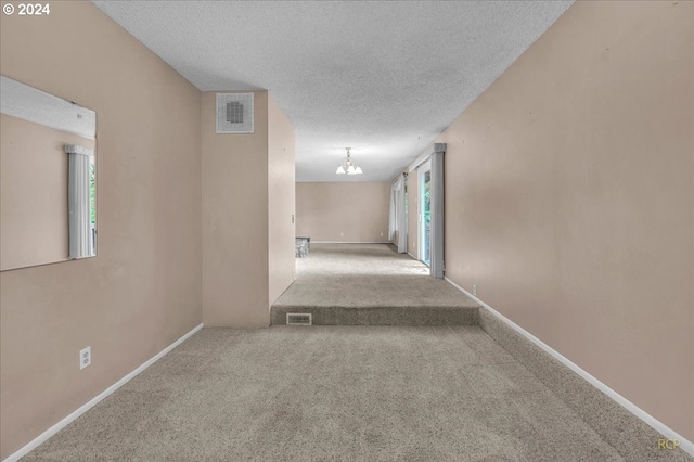 corridor with a textured ceiling and carpet