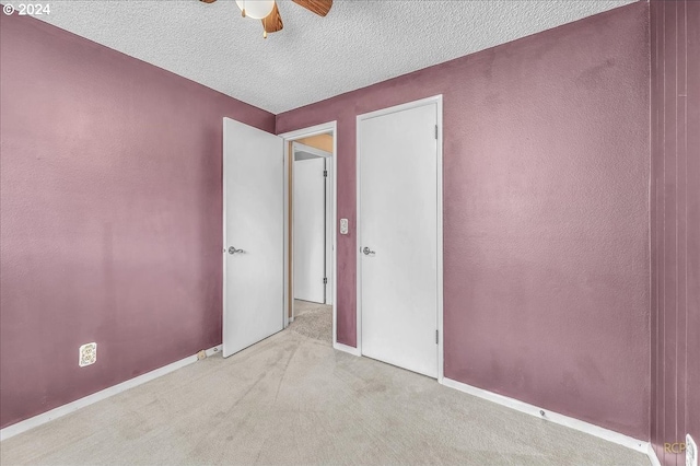 carpeted empty room with a textured ceiling and ceiling fan