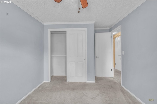 unfurnished bedroom with a textured ceiling, light colored carpet, ceiling fan, and a closet