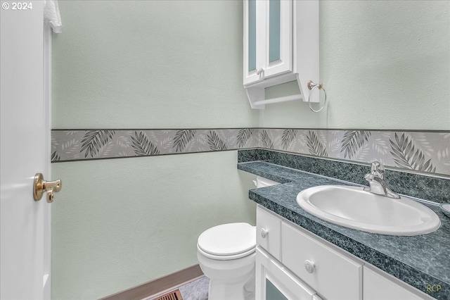 bathroom featuring toilet and vanity