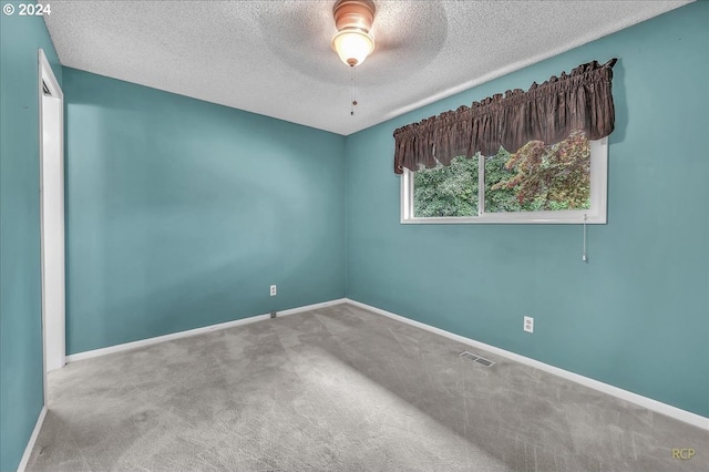 unfurnished room with a textured ceiling, ceiling fan, and carpet floors