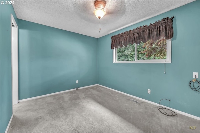 carpeted spare room with a textured ceiling and ceiling fan