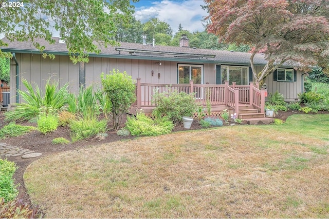 exterior space featuring a front lawn, central AC, and a deck