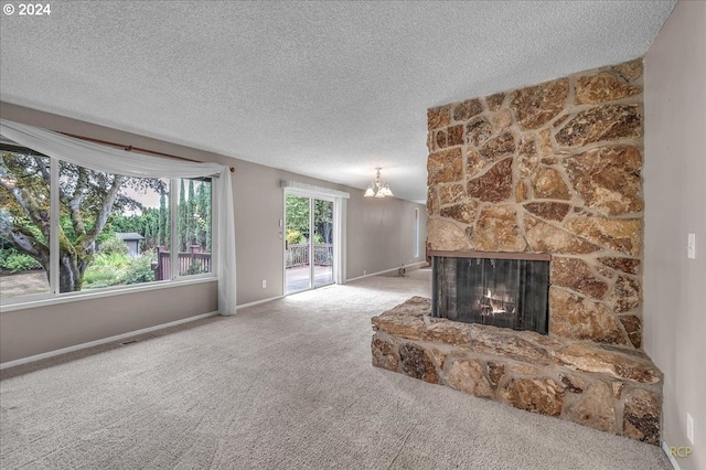 living room with carpet flooring, a textured ceiling, an inviting chandelier, and a stone fireplace