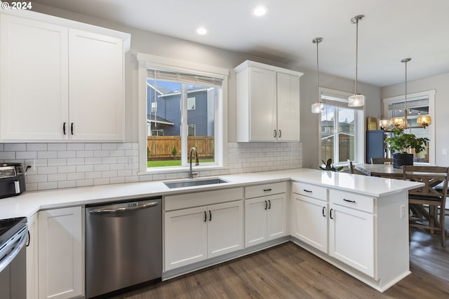 kitchen with kitchen peninsula, appliances with stainless steel finishes, sink, dark hardwood / wood-style floors, and white cabinetry