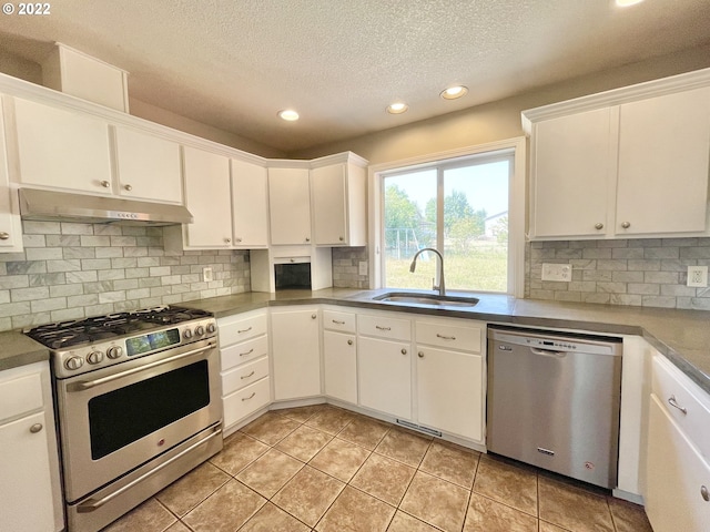 kitchen with backsplash, sink, appliances with stainless steel finishes, and white cabinetry