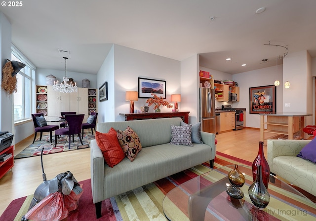 living room featuring an inviting chandelier and light hardwood / wood-style flooring