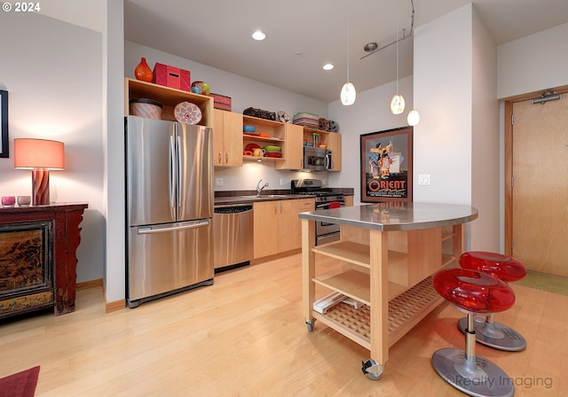 kitchen with pendant lighting, stainless steel appliances, light hardwood / wood-style floors, stainless steel counters, and light brown cabinets