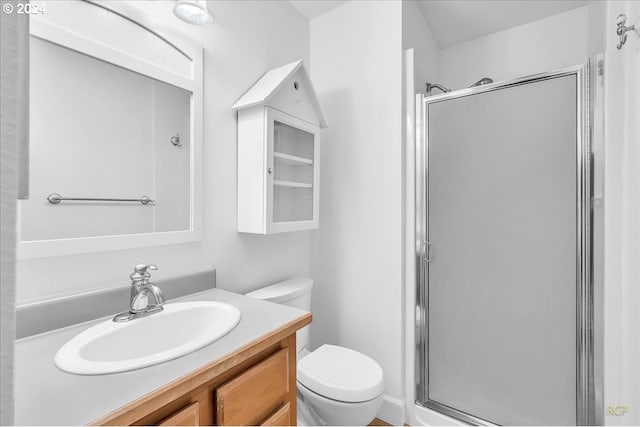 bathroom featuring vanity, toilet, and an enclosed shower