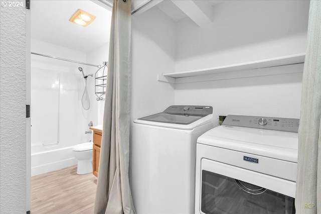 laundry area featuring washer and dryer and light wood-type flooring