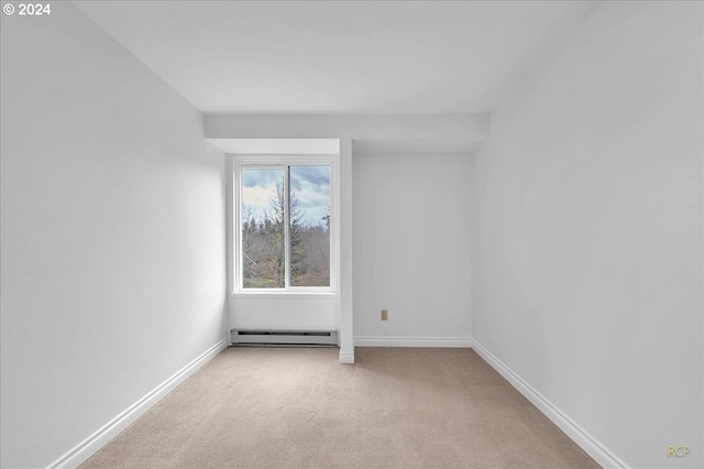 carpeted empty room featuring baseboard heating