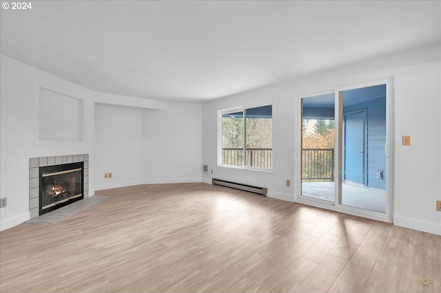 unfurnished living room with a tile fireplace, light hardwood / wood-style flooring, and a baseboard radiator