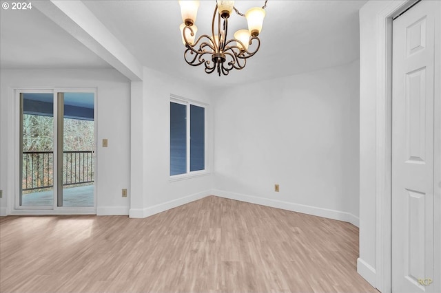 unfurnished dining area featuring light wood-type flooring and an inviting chandelier