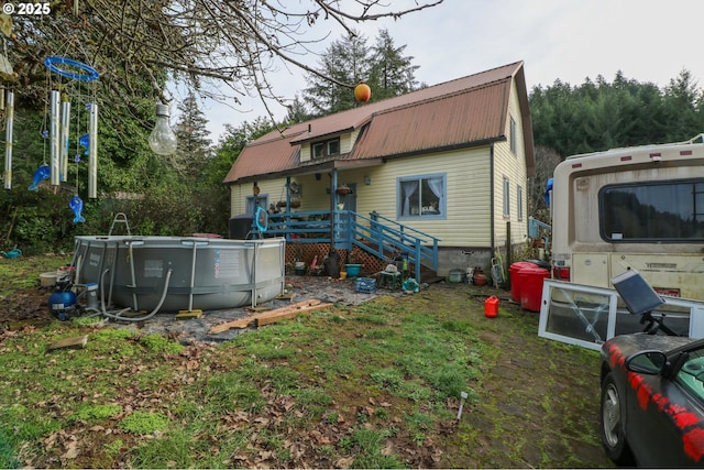 back of house featuring a swimming pool side deck