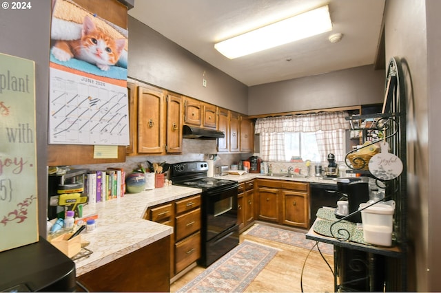 kitchen with decorative backsplash, kitchen peninsula, sink, black appliances, and light tile patterned flooring