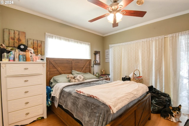 bedroom featuring hardwood / wood-style flooring, ceiling fan, and ornamental molding