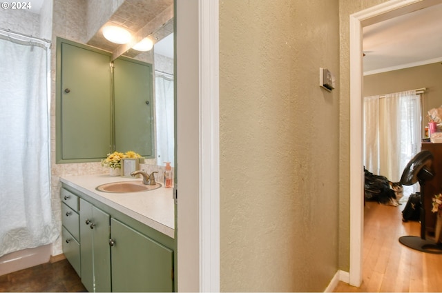 bathroom featuring vanity, wood-type flooring, and ornamental molding