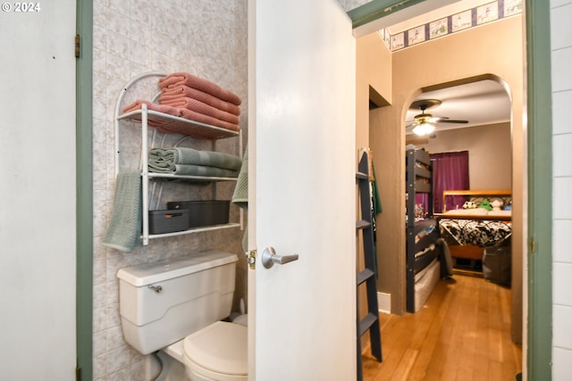 bathroom featuring hardwood / wood-style floors, toilet, ceiling fan, and crown molding