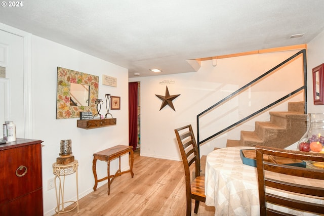 dining space featuring a textured ceiling and light wood-type flooring