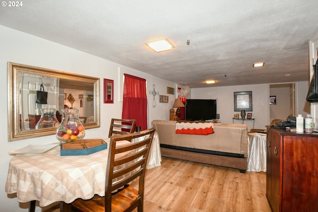 dining space with a textured ceiling and light hardwood / wood-style floors