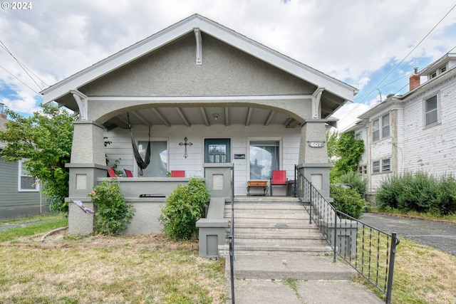 view of front of home with covered porch and a front lawn